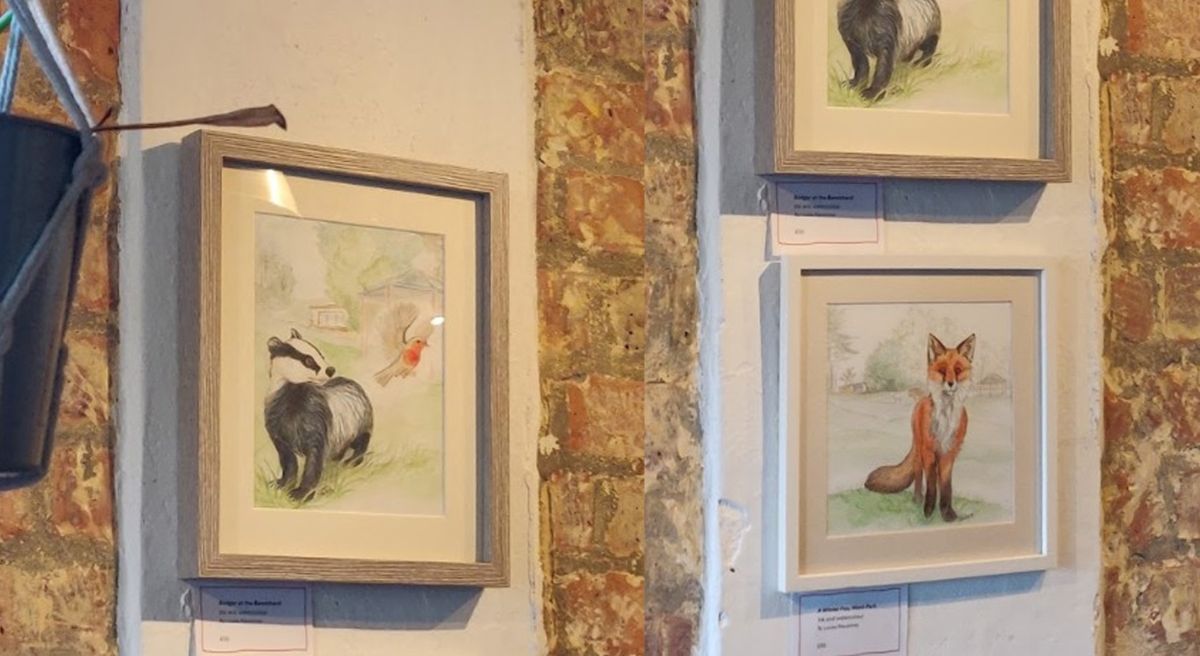Framed paintings of a badger and a fox.